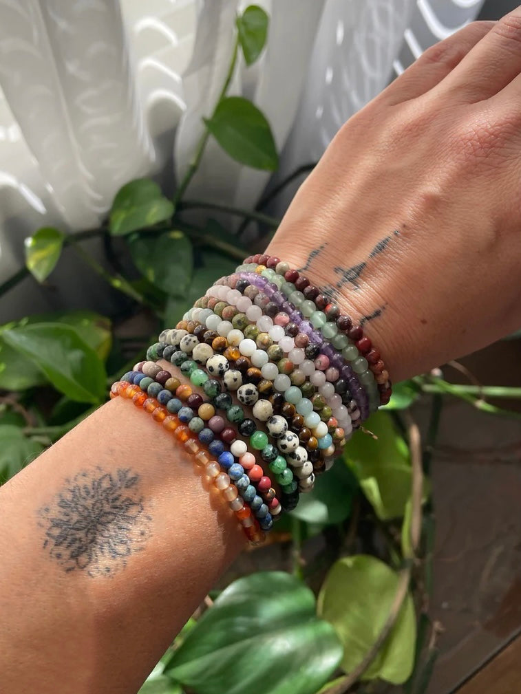 A wrist shot showing three different stacking stretch bracelets made with 4mm Sodalite, Labradorite, and Moss Agate stones.