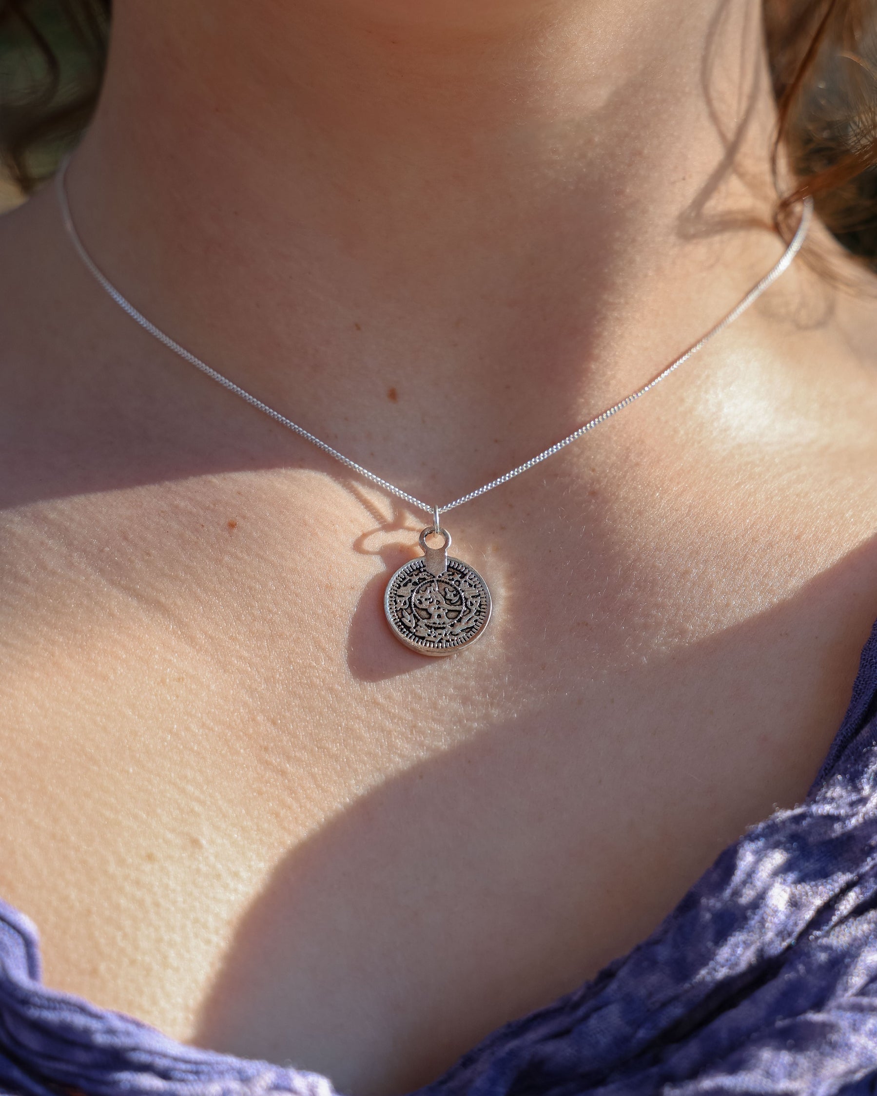 Close-up of a necklace with a pendant on a person's neck