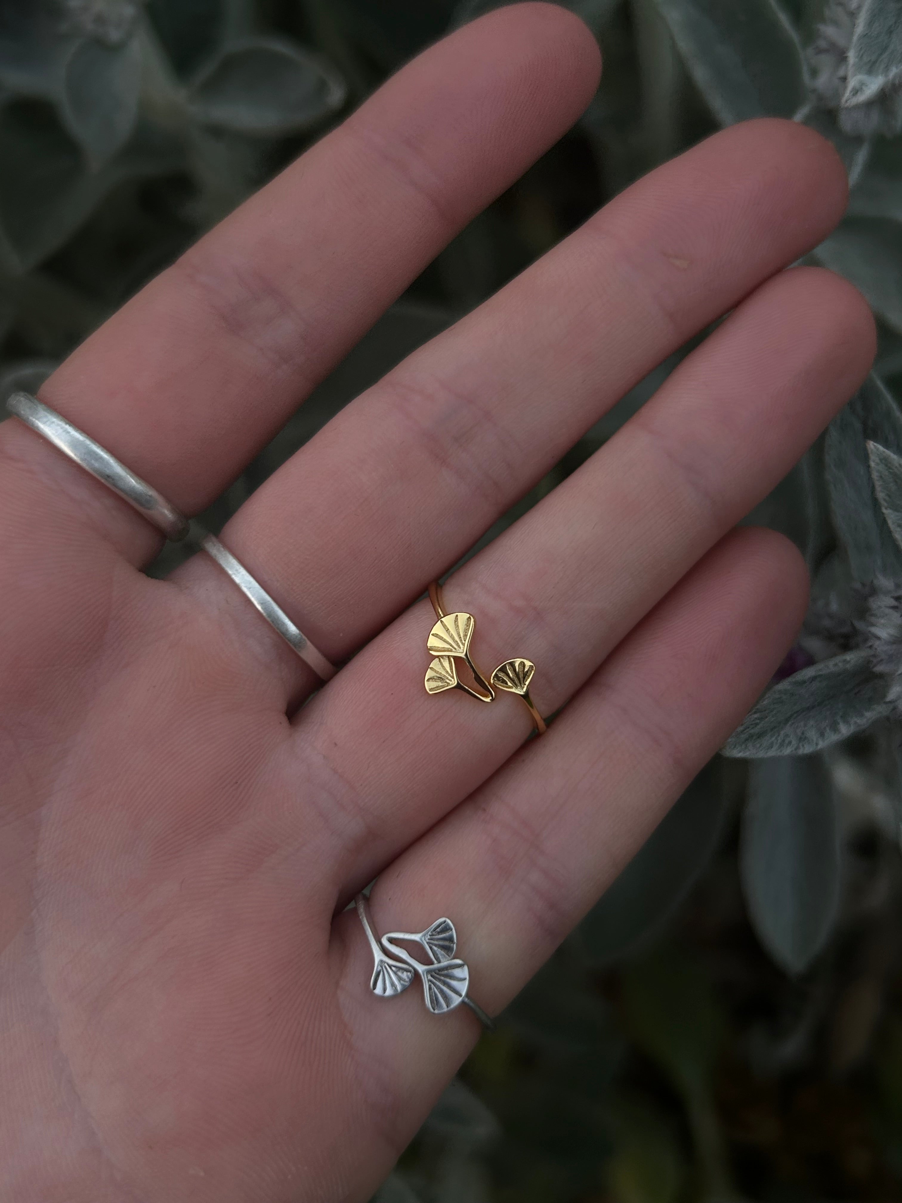 Close-up on hand of the Handmade Gold and silver Ginkgo Ring showing the intricate, adjustable floral plant design.