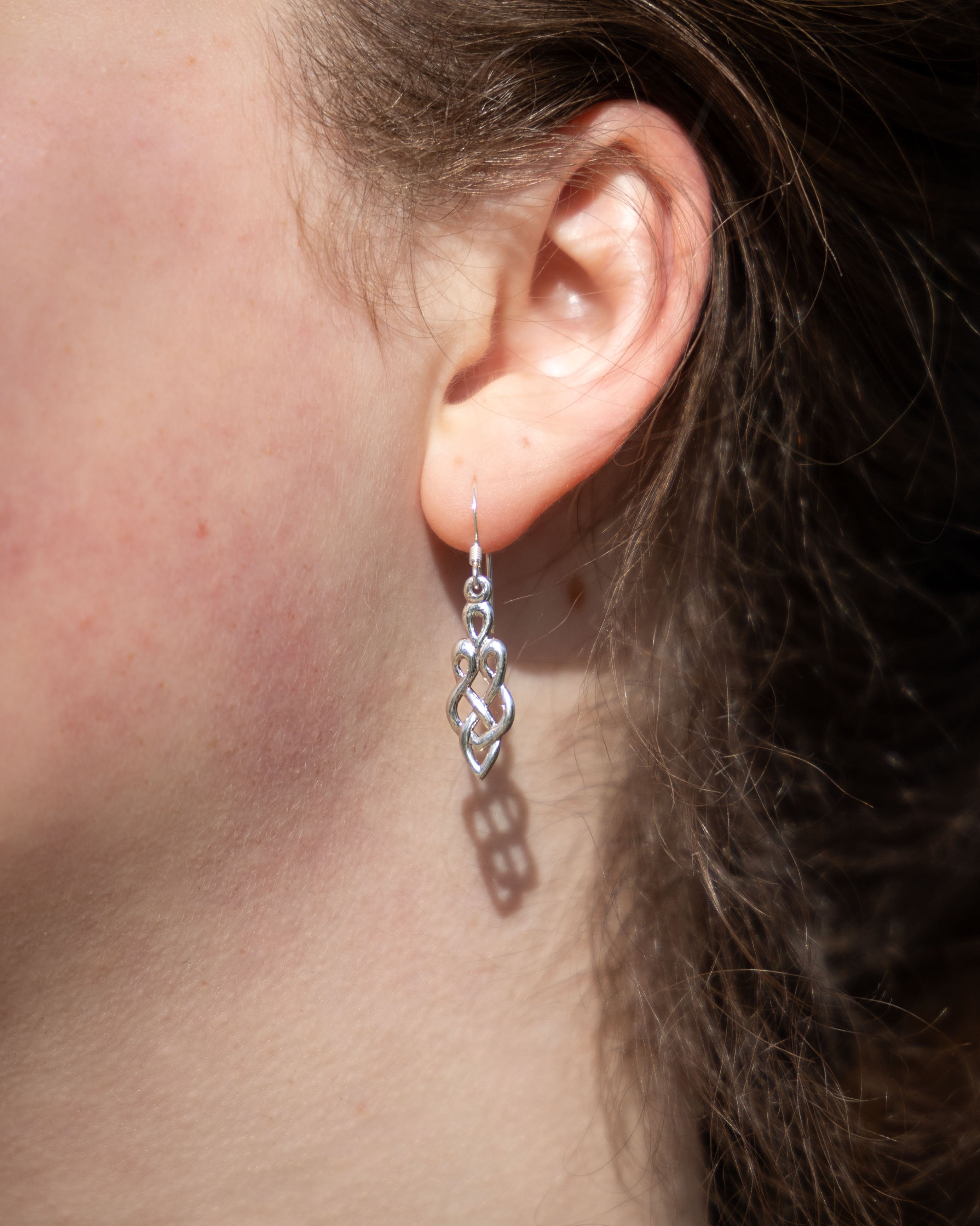 Close-up of an ear with a silver Celtic earring