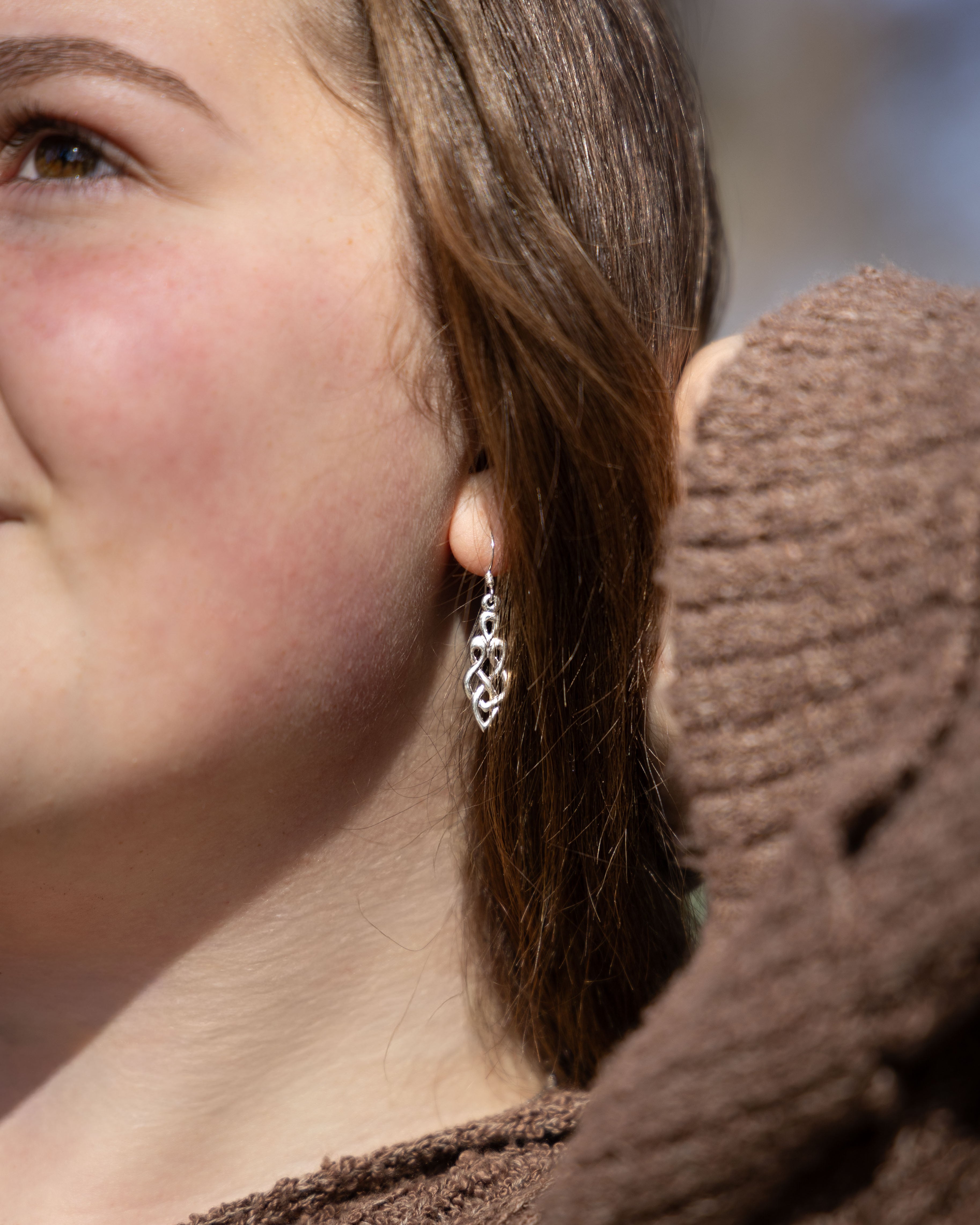 Close-up of an ear with a silver Celtic earring