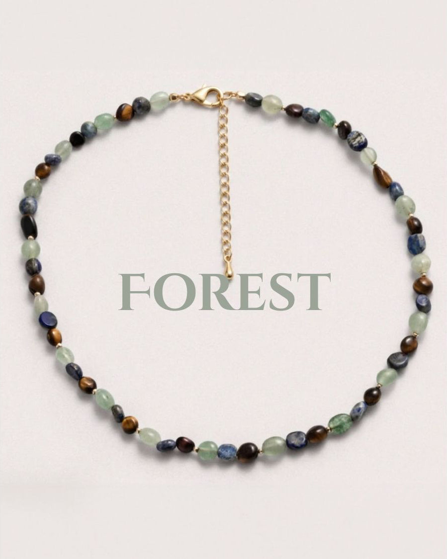 Necklace with multicolored beads and gold clasp on a white background, labeled 'FOREST'.