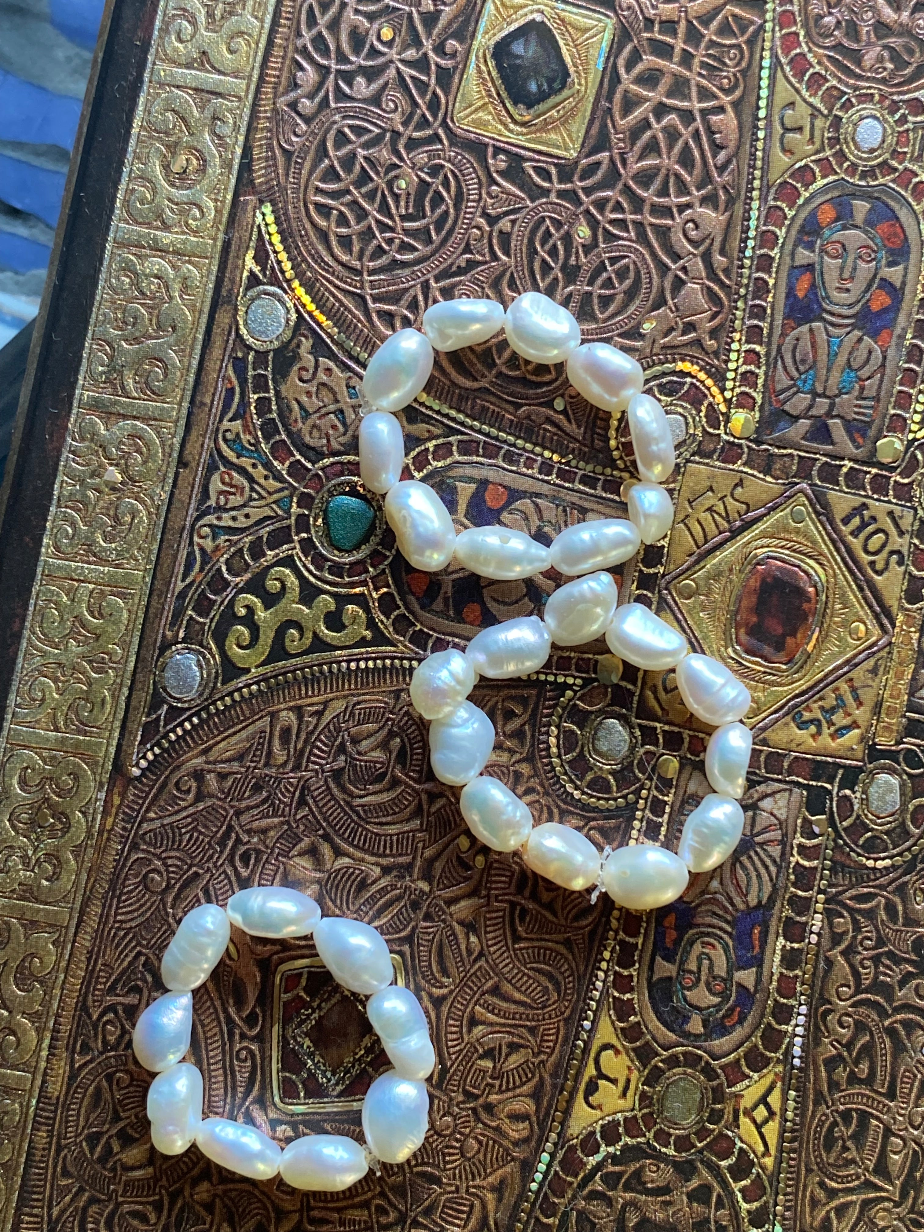 Pearl rings on an ornate, patterned surface