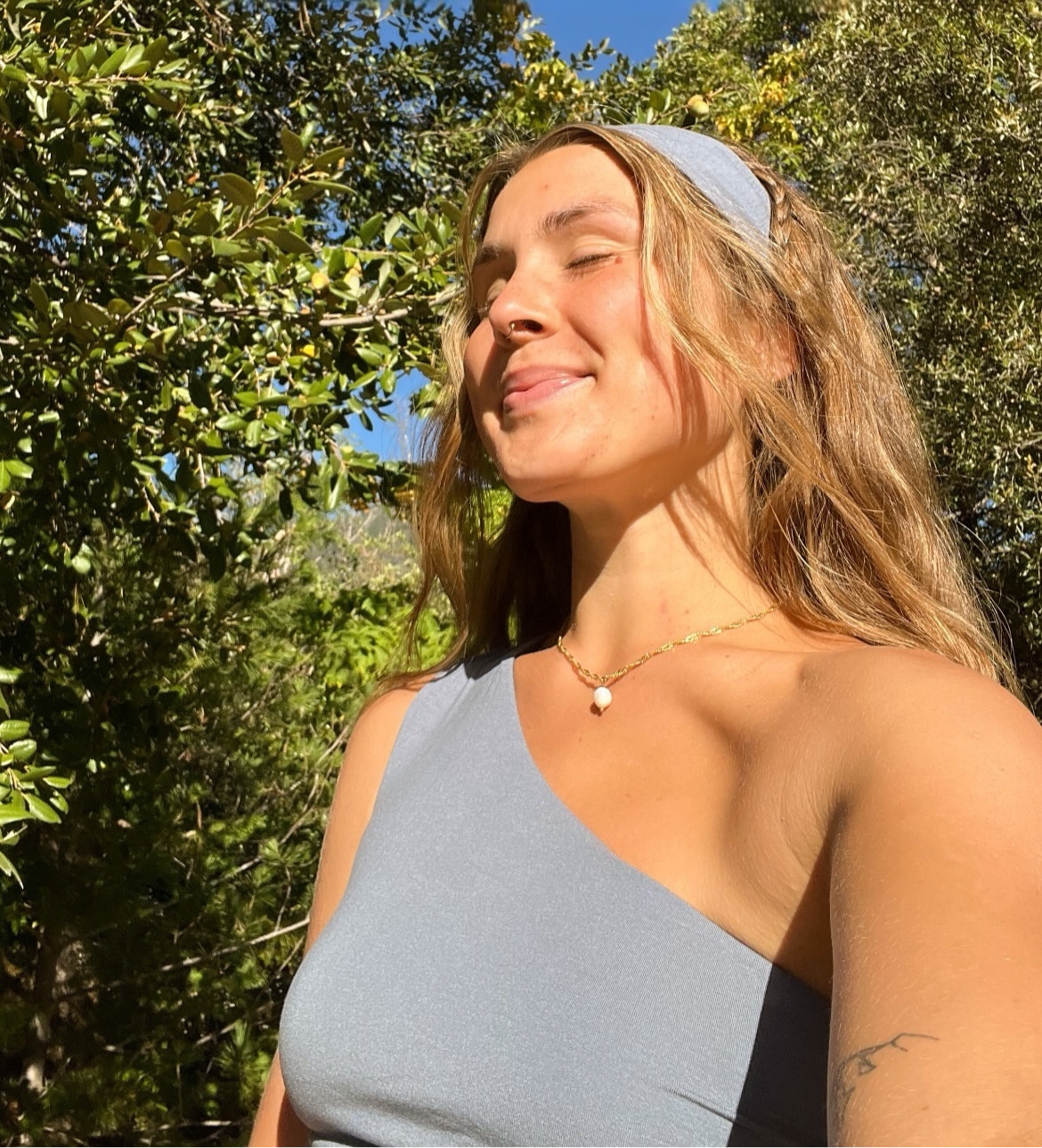 model wearing the Classic Gold Pearl Necklace, showing the subtle single pearl drop pendant in sunlight.