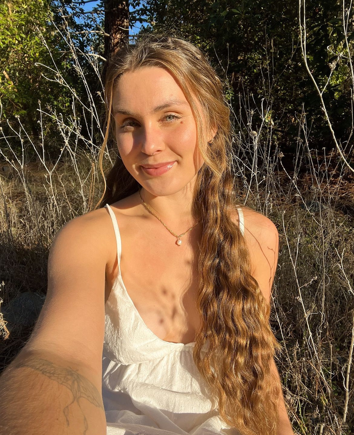 model wearing the Classic gold Pearl Necklace, showing the subtle single pearl drop pendant detail in sunlight
