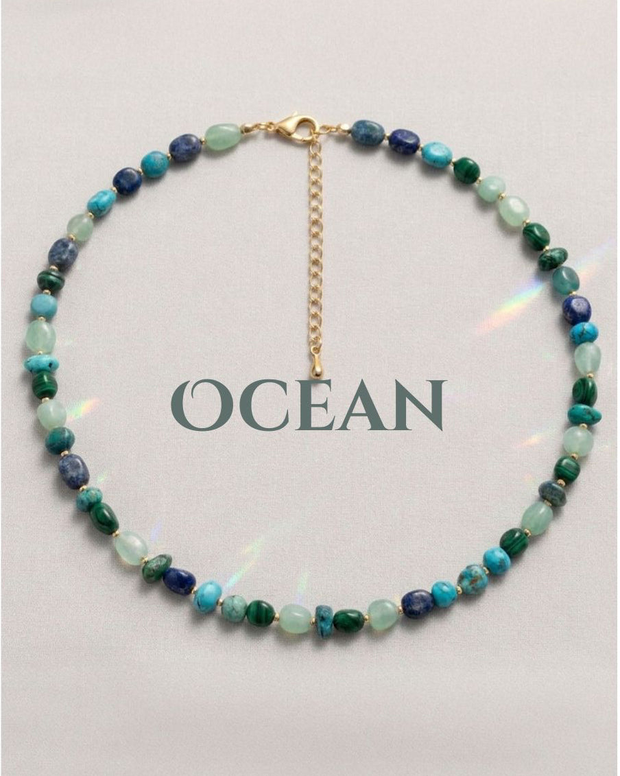 Beaded necklace with 'OCEAN' text on a light gray background