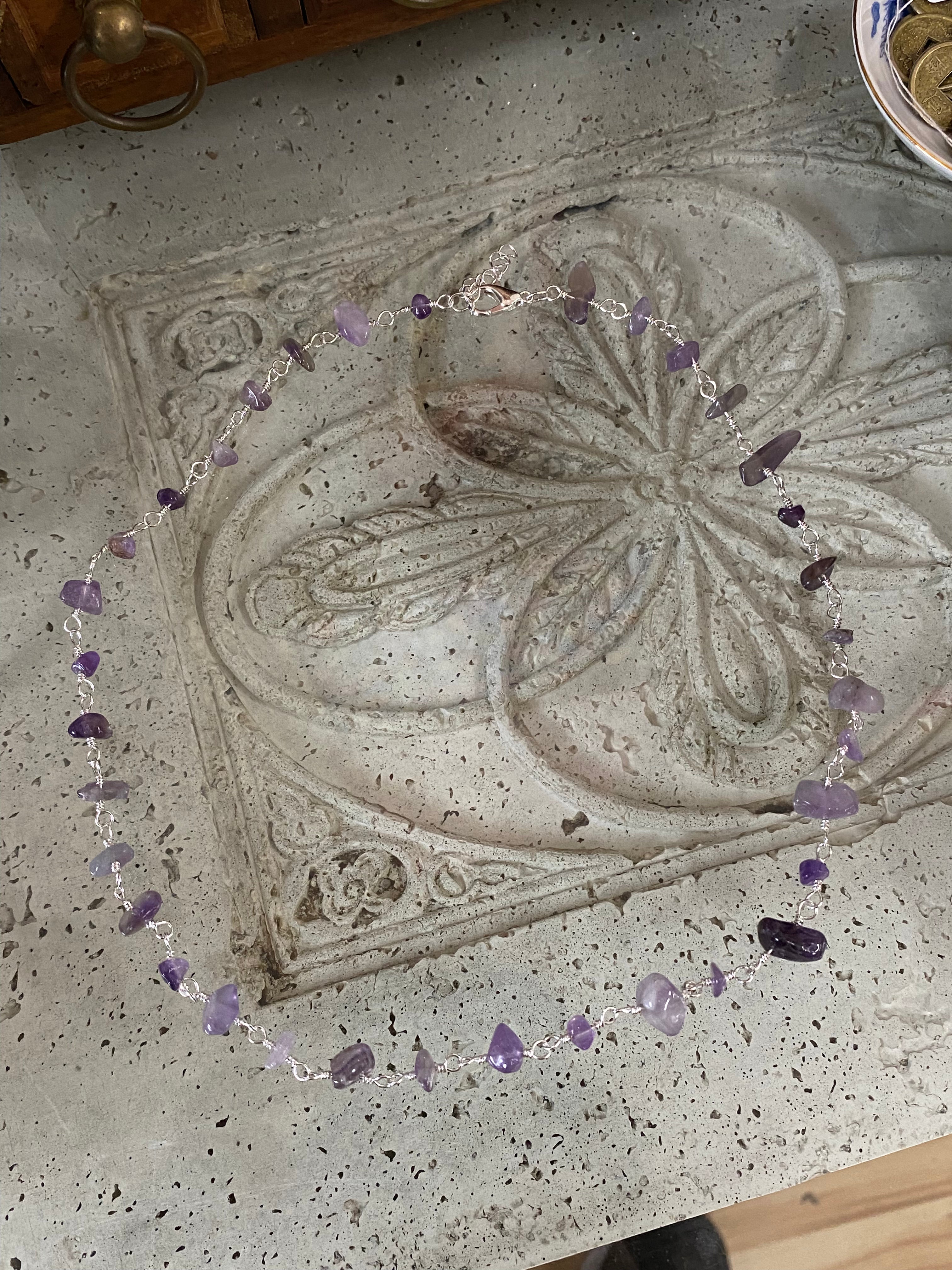 flat lay of Raw Amethyst Necklace showing the natural, rough-cut purple stone chips set on a delicate Amethyst Necklace silver Chain.