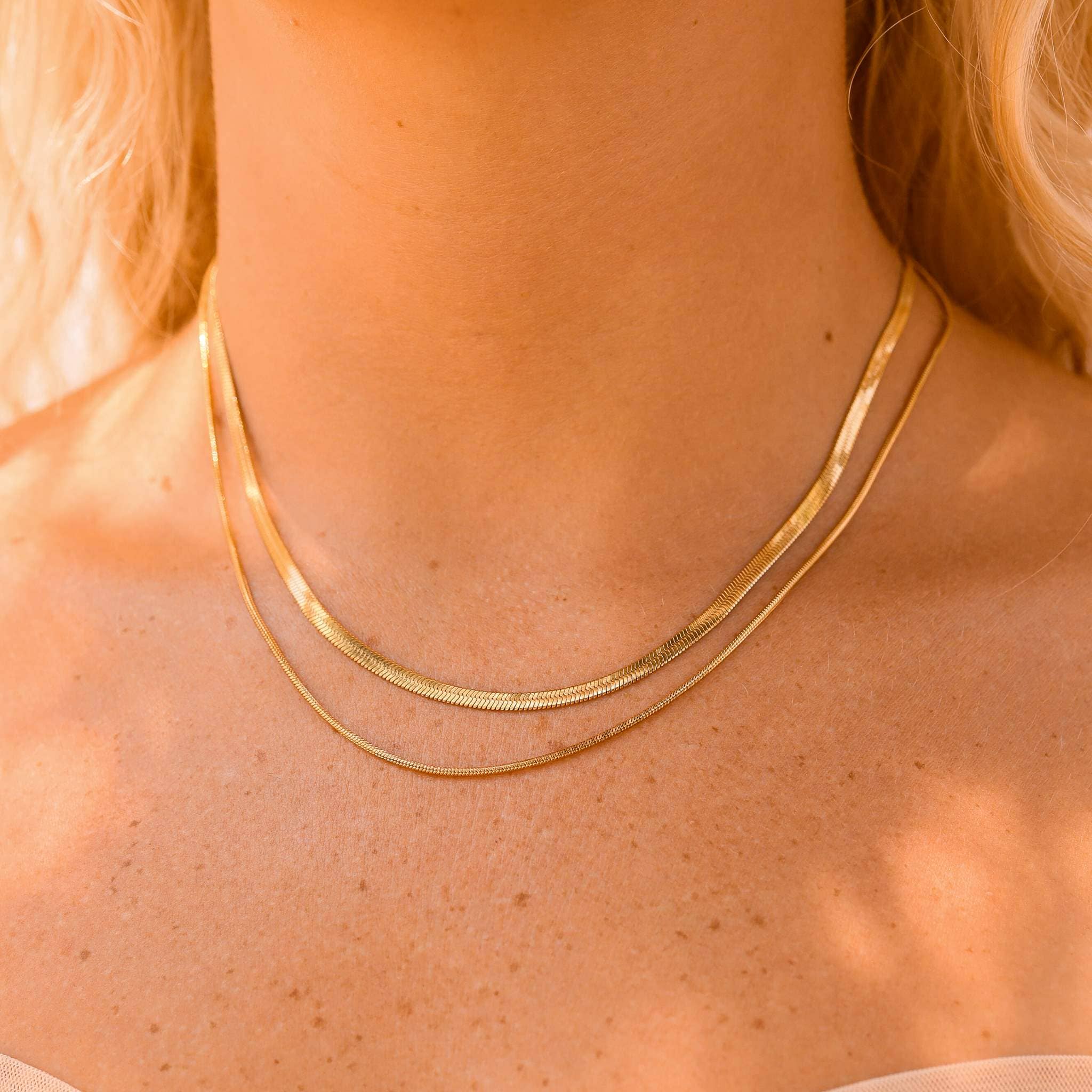 Gold necklace on a person with blonde hair