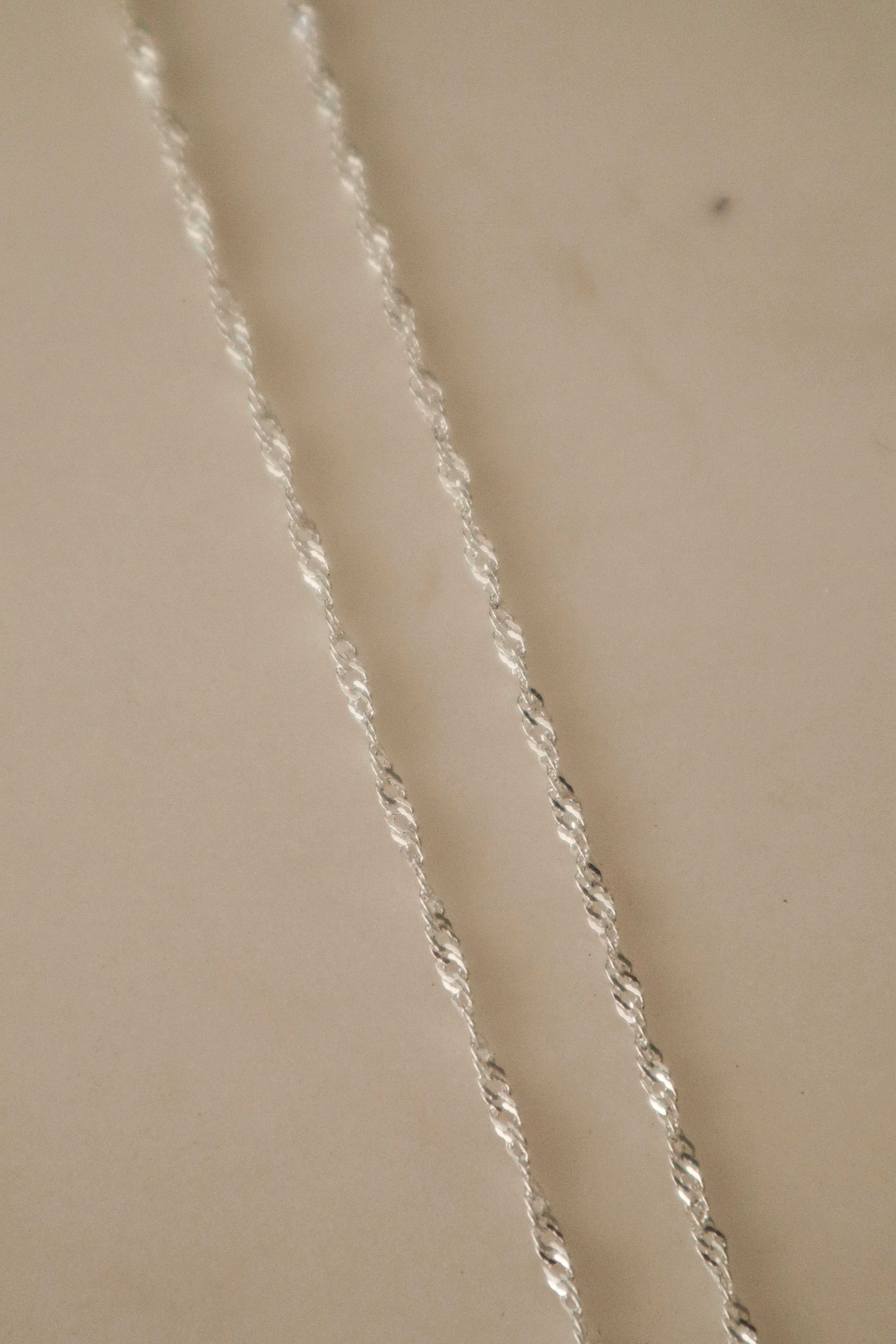 Close-up of the 925 sterling silver Singapore Chain, highlighting the intricate multi-link twist detailing