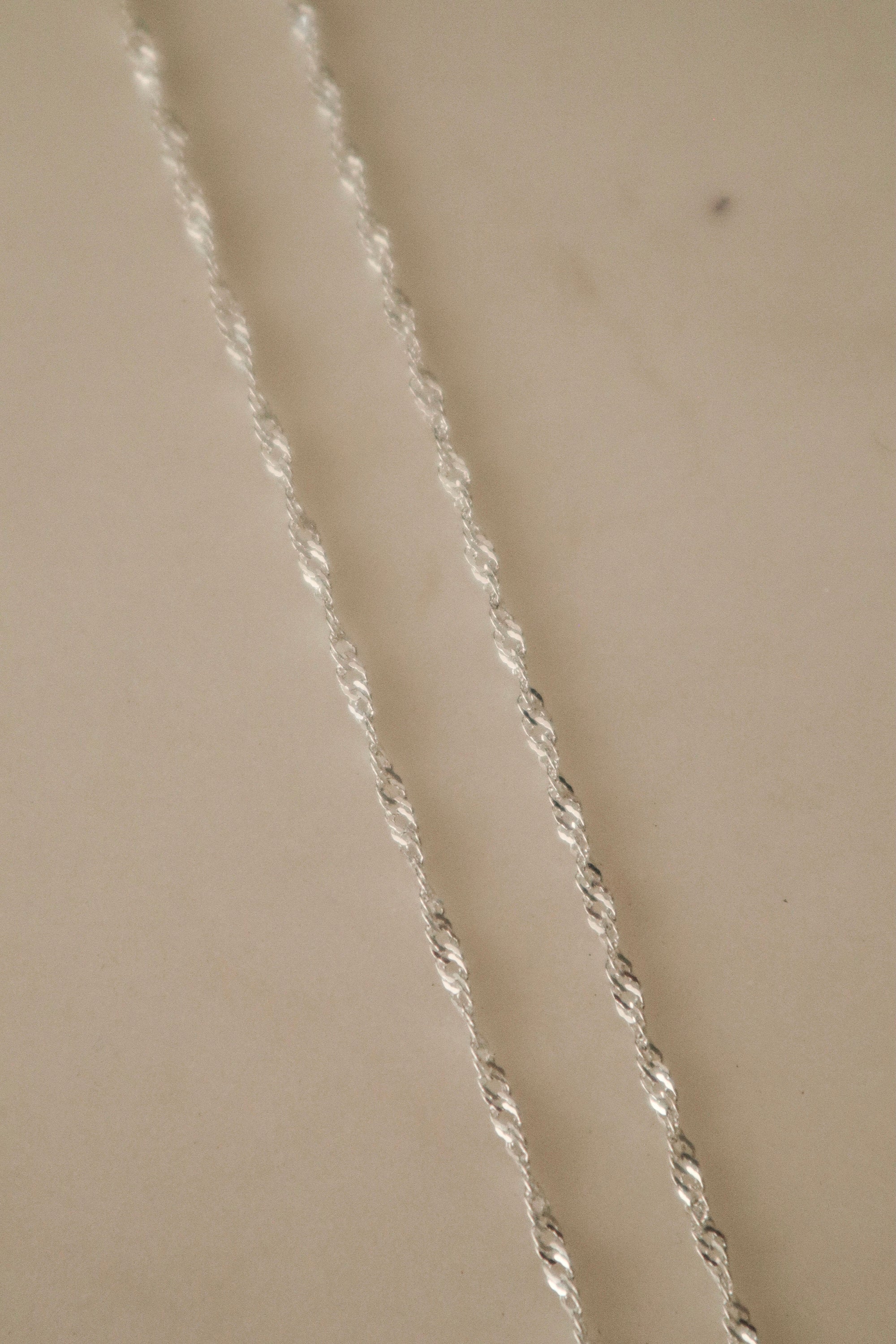 Close-up of the 925 sterling silver Singapore Chain, highlighting the intricate multi-link twist detailing