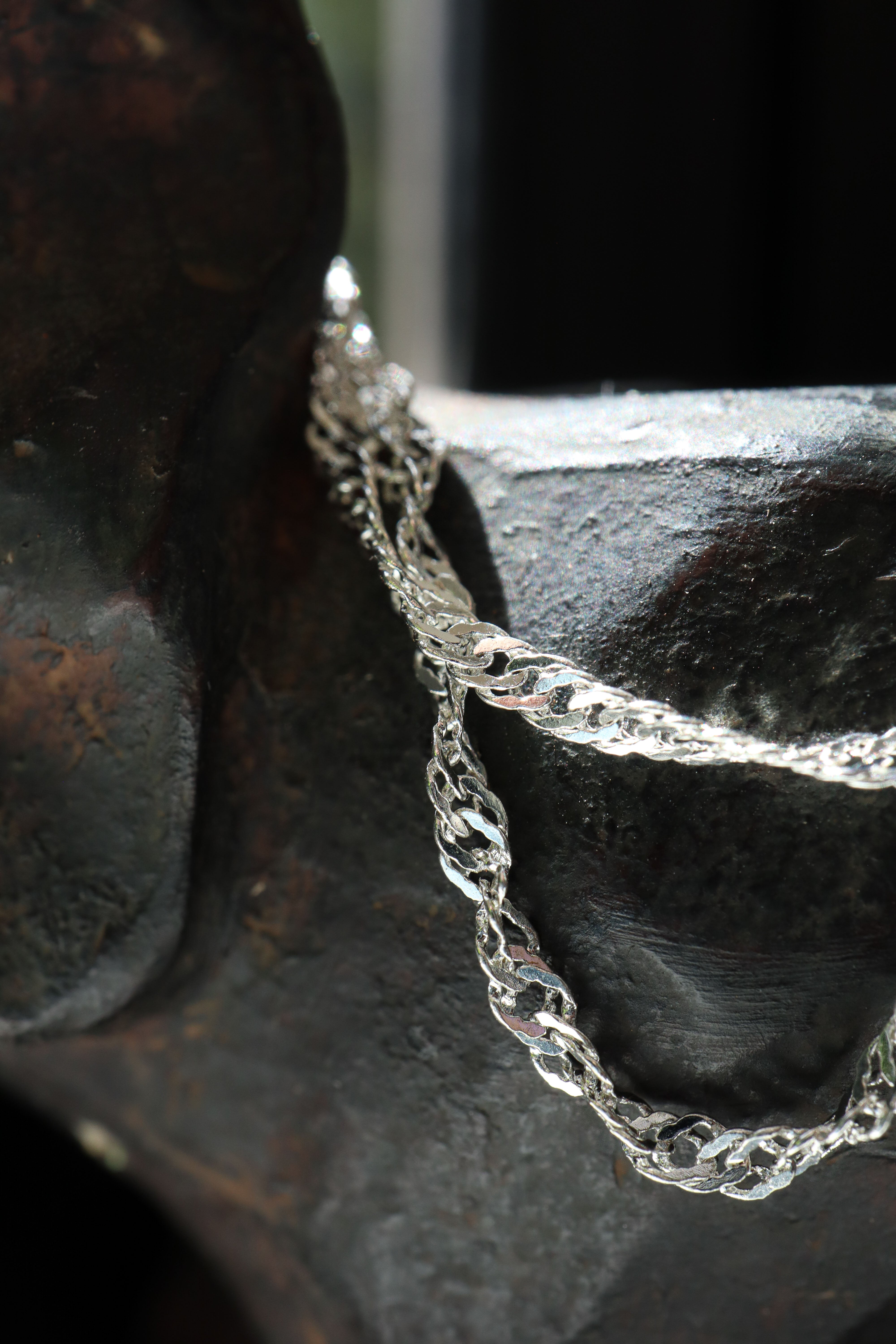 macro close-up of the 925 sterling silver Singapore Chain, highlighting the intricate multi-link twist detailing