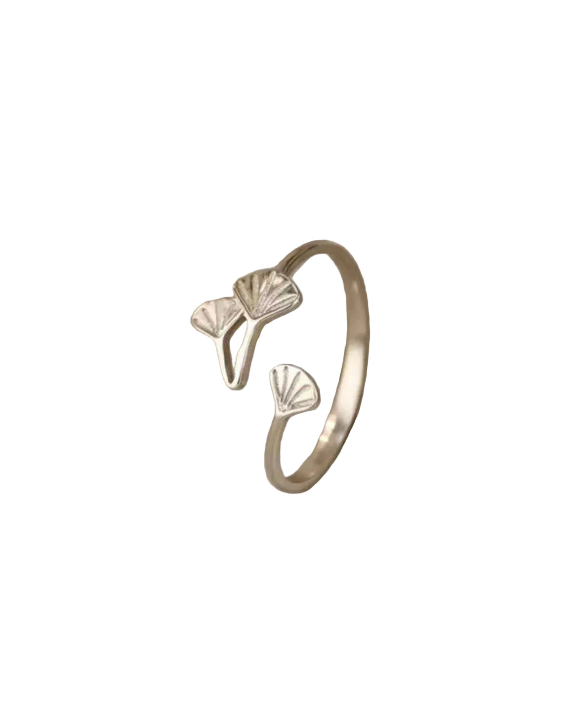 Silver ring with leaf designs on a soft beige fabric background