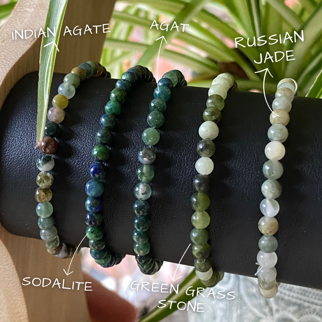 a display stand showing three different stacking stretch bracelets made with 4mm Indian agate, Agat, Russian jade, Sodalite and green grass stone.