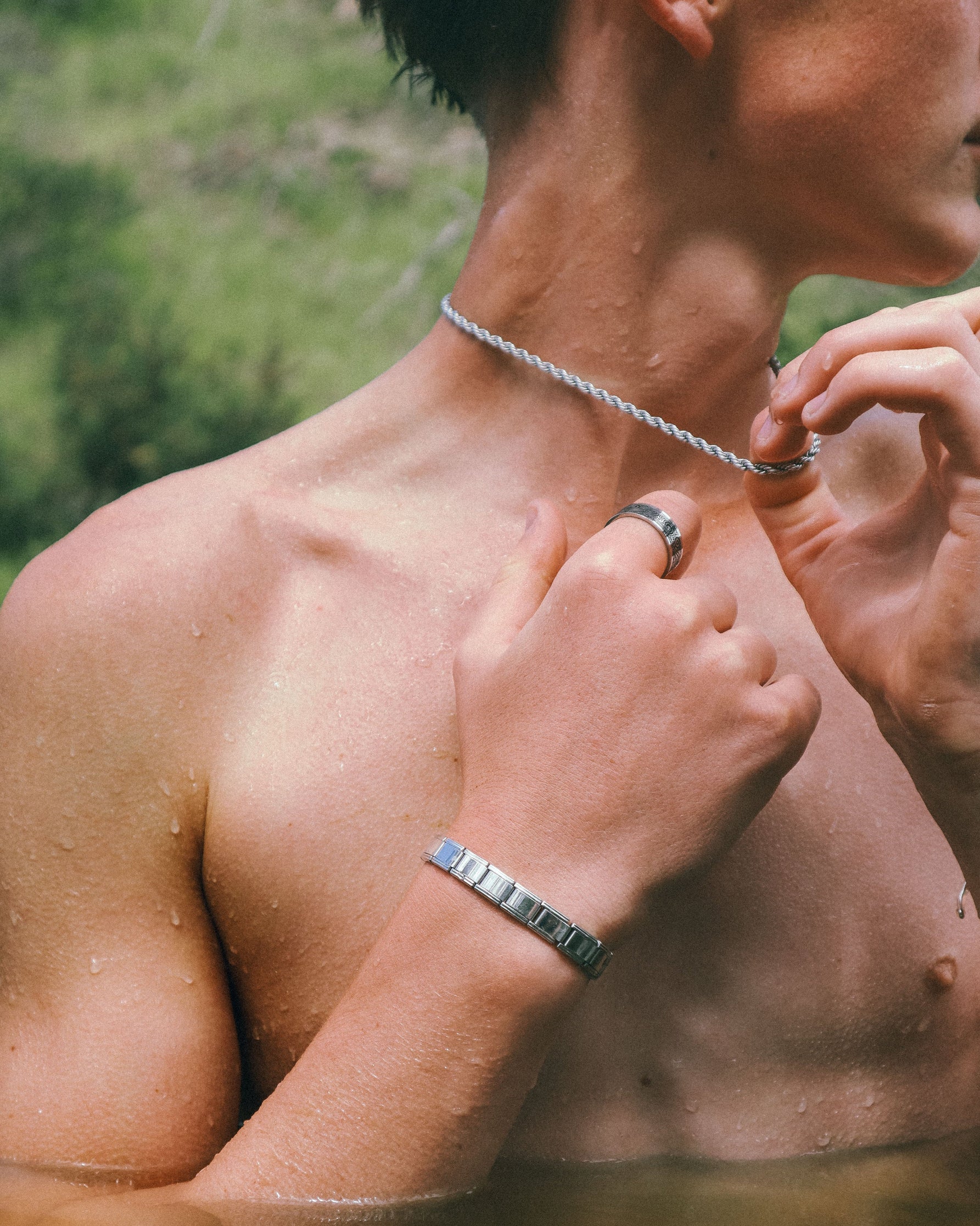 Close-up of a person's torso wearing jewellery with a blurred background