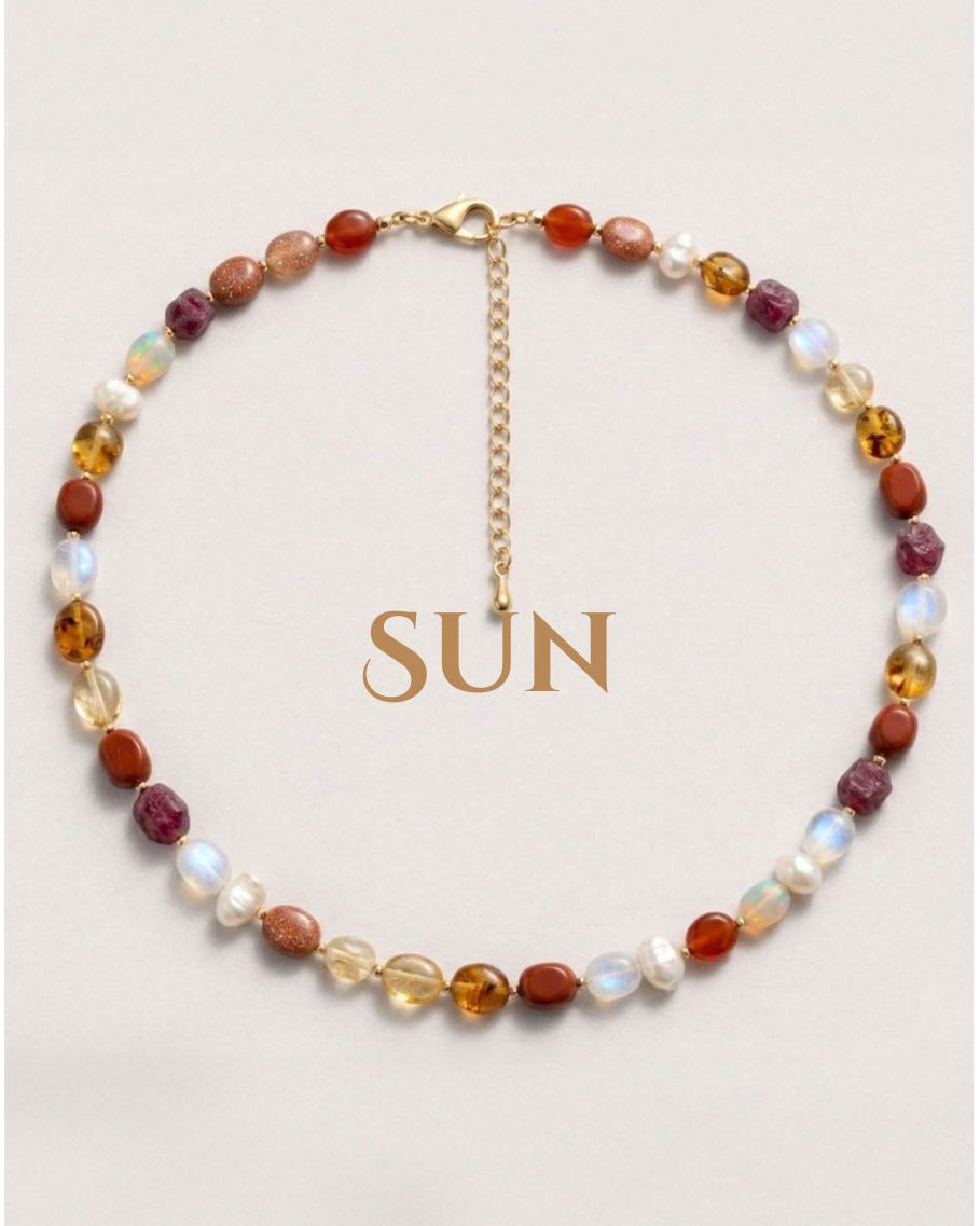 Necklace with multicolored beads and a gold chain on a light background