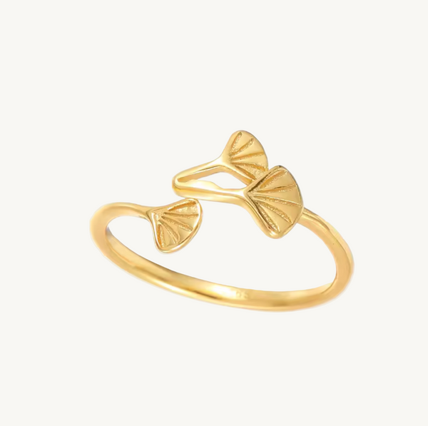 Gold ring with leaf designs on a white background