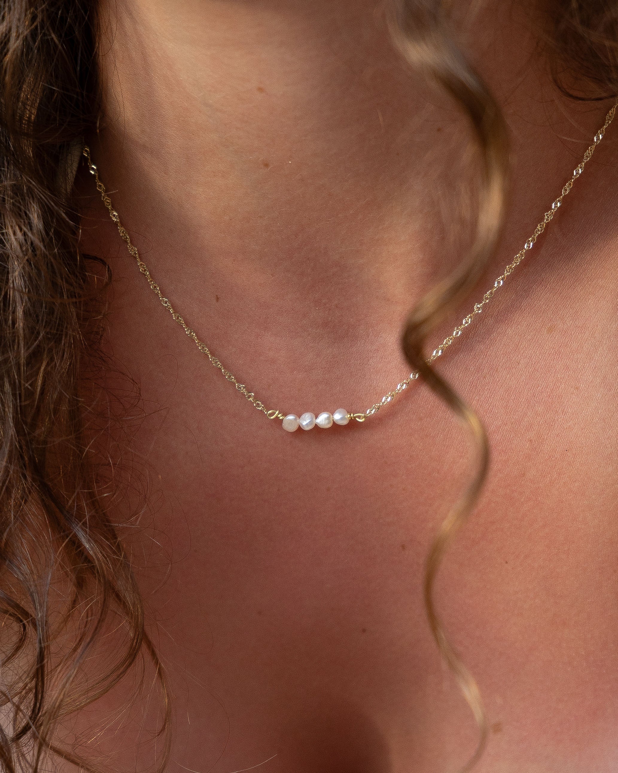 Close-up of a delicate pearls on a gold chain 