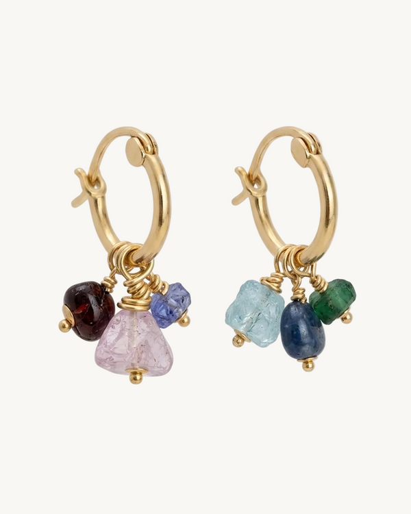 Gold hoop earrings with multicolored gemstones on a white background