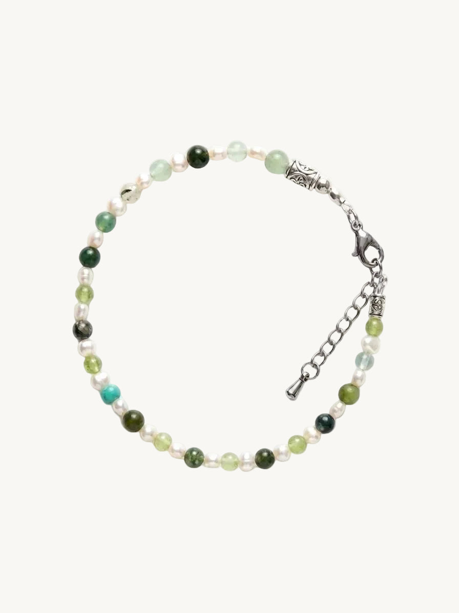 Beaded bracelet with green and silver elements on a white background