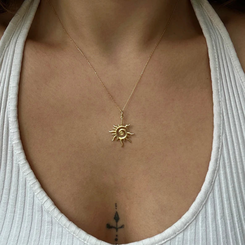Close-up of a model wearing the dainty gold sun necklace showing the 16-inch chain length and minimal sunburst design.