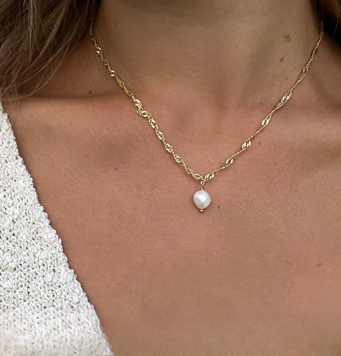 Close-up of a model wearing the Classic Gold Pearl Necklace, showing the subtle single pearl drop pendant detail.