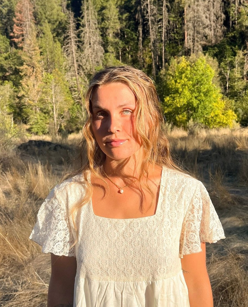 model wearing the Classic Gold Pearl Necklace, showing the subtle single pearl drop pendant in sunlight.