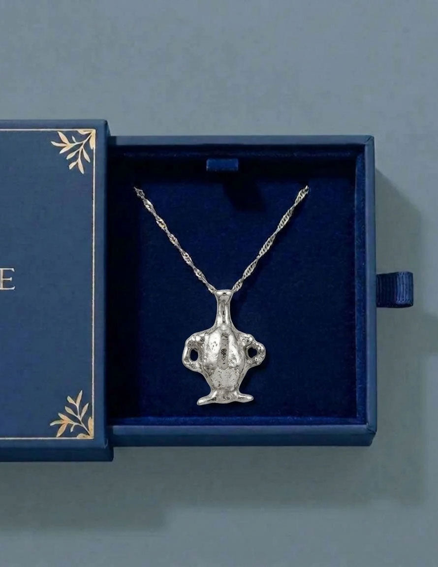Silver necklace with a pendant in an open blue jewelry box on a gray background