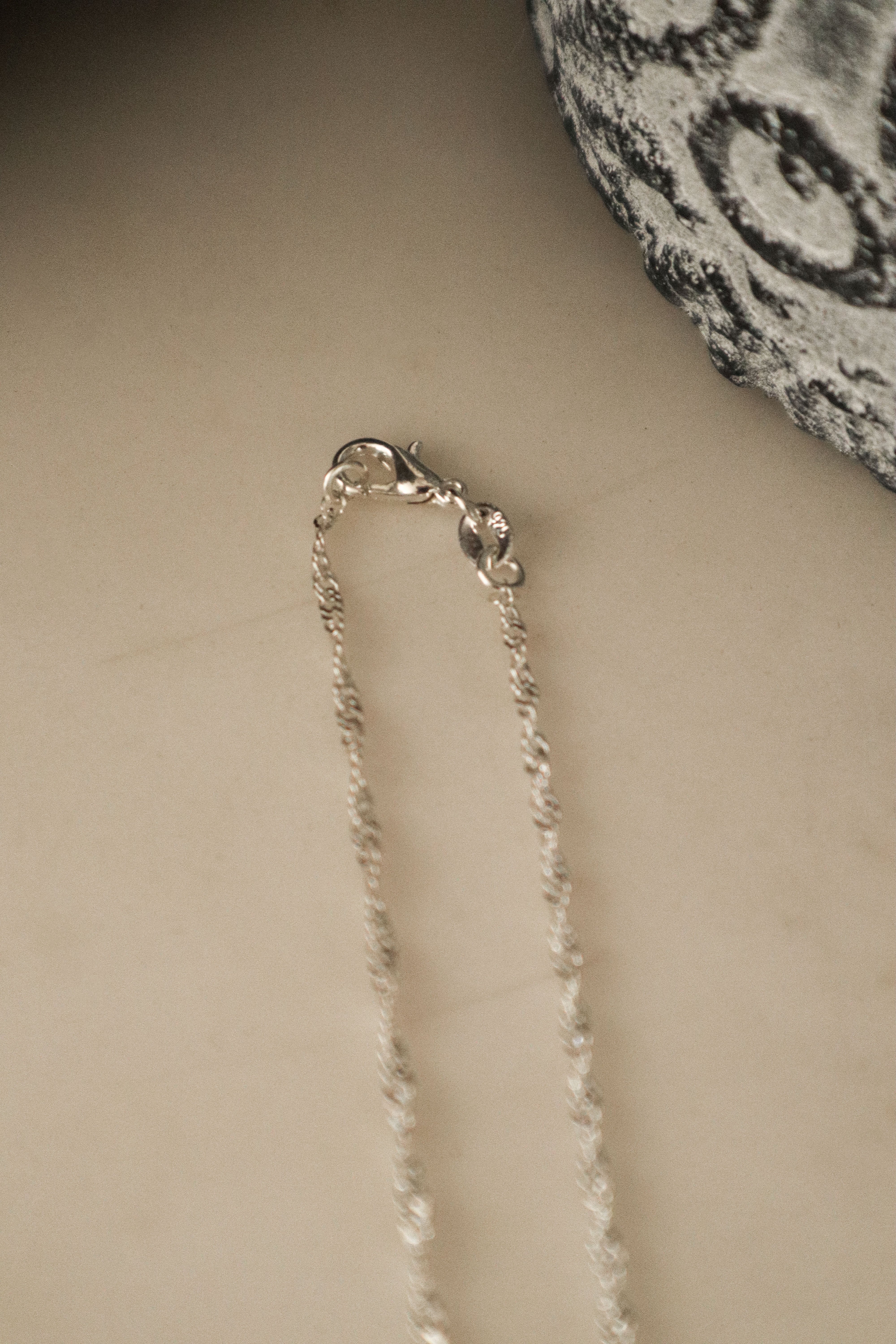 Close-up of the 925 sterling silver Singapore Chain, highlighting the intricate multi-link twist detailing and clasp. 