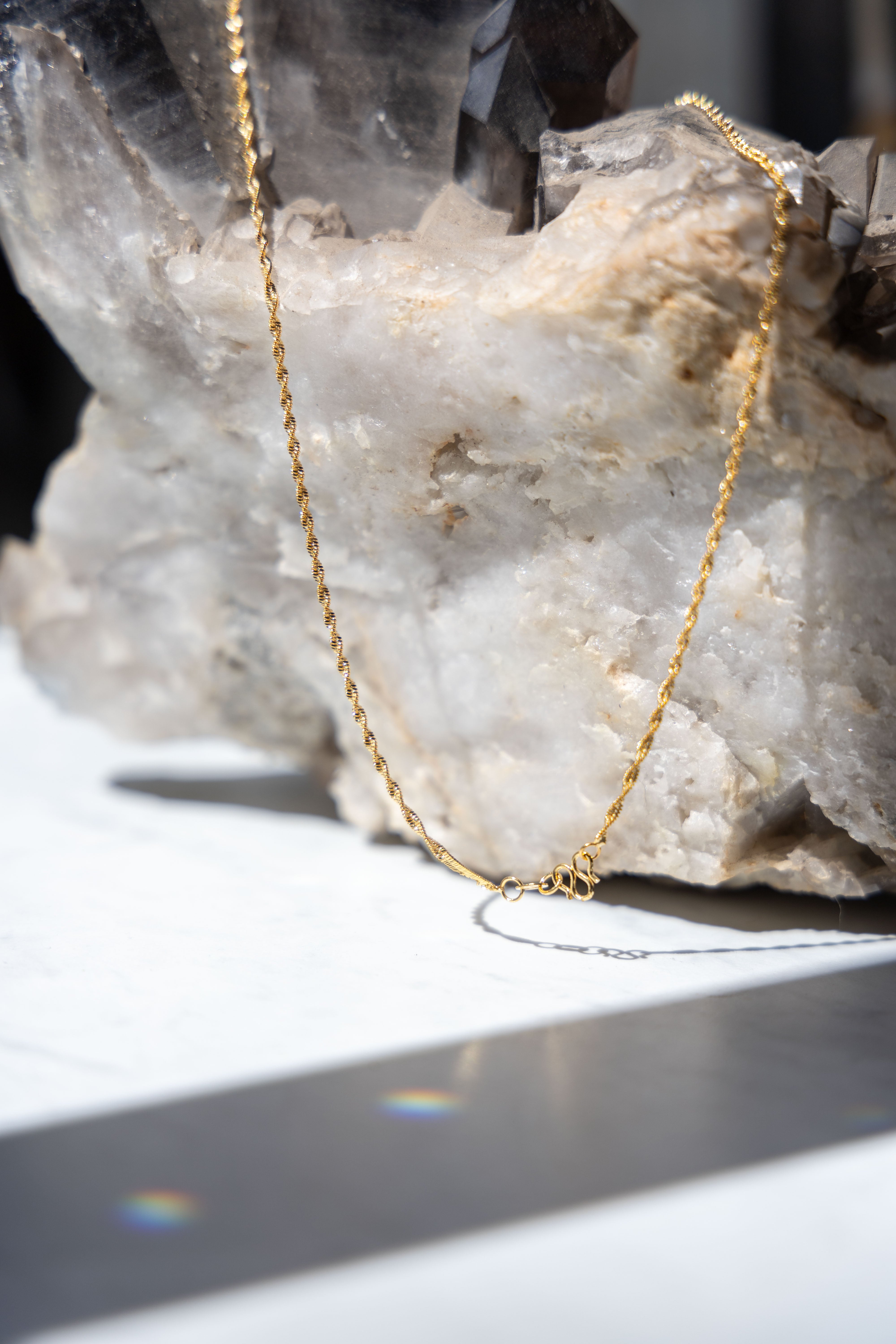Close-up of the 14k gold Singapore Chain, highlighting the intricate multi-link twist detailing and clasp. 